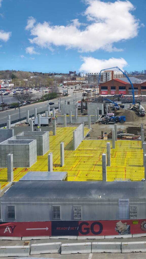 Aerial view of the Arsenal Yards construction site, showcasing utilities being installed for the mixed-use development in Watertown, MA.