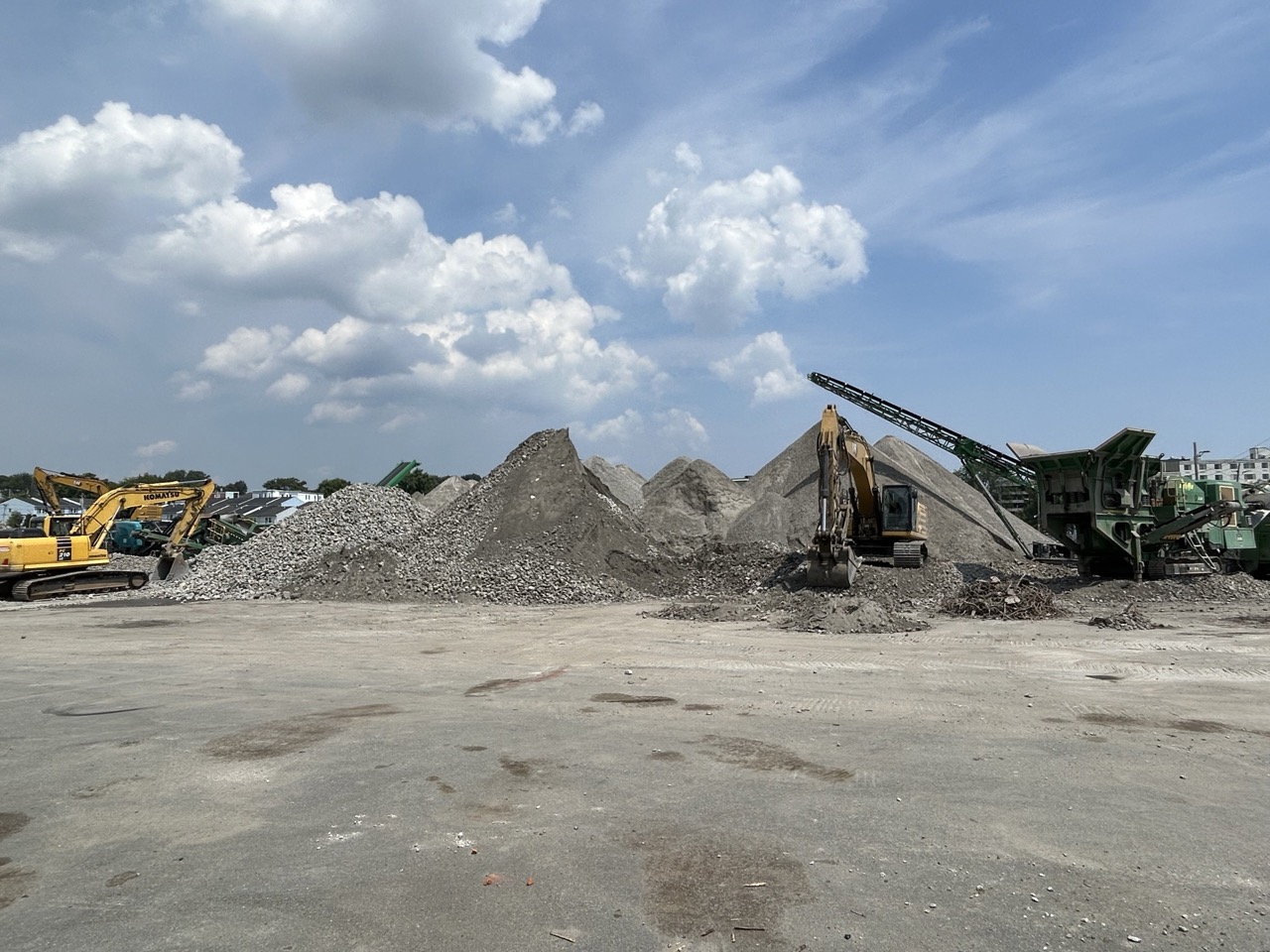Excavators and concrete crushing equipment processing demolished material at Chelsea Point in Franklin, MA