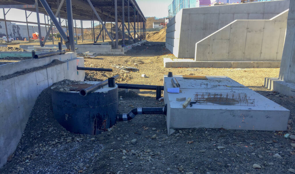 Construction site with sewer infrastructure visible.