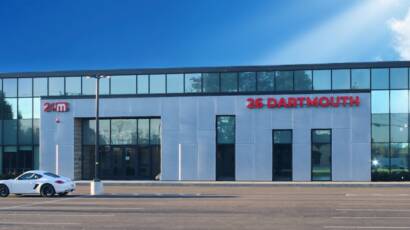 Front entrance of 24M building in Westwood Massachusetts with modern glass facade and signage