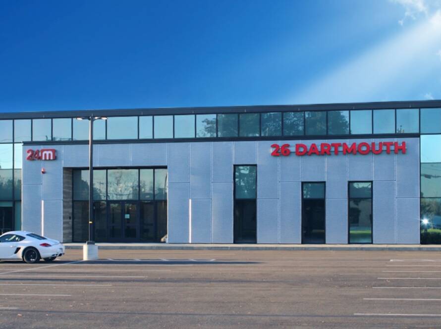 Front entrance of 24M building in Westwood Massachusetts with modern glass facade and signage