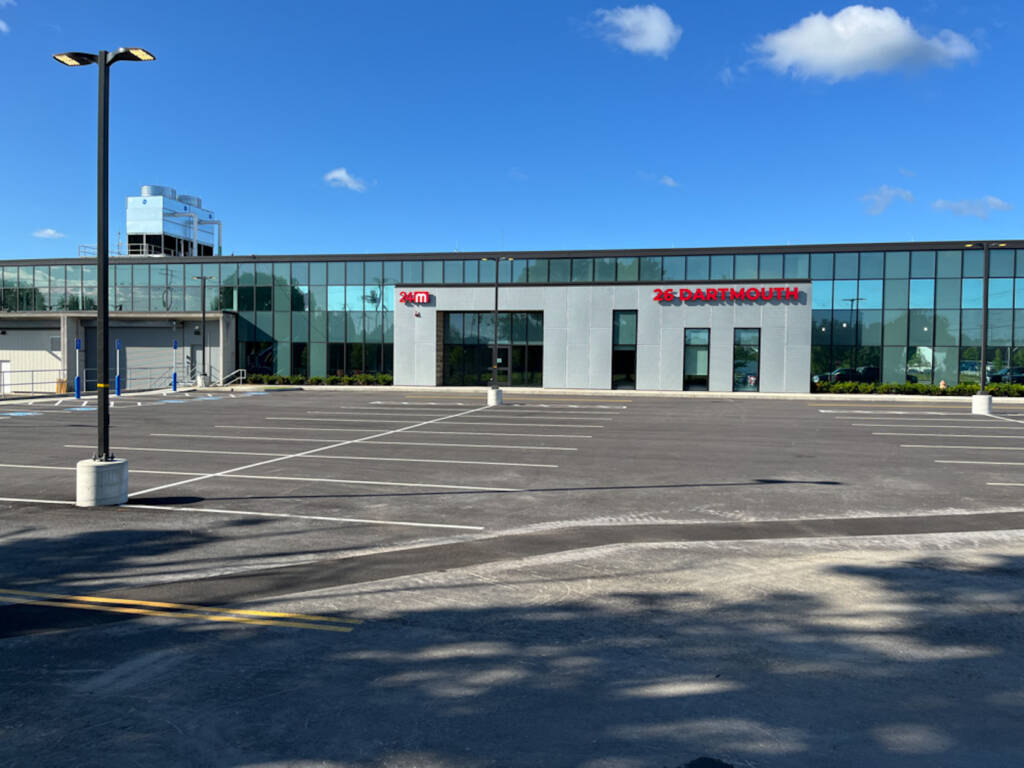 Wide view of 24M commercial building in Westwood MA with glass exterior and newly constructed parking lot