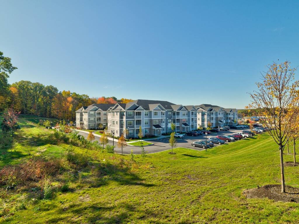Edgemere Crossing multifamily in Shrewsbury MA with grass hill on sunny day
