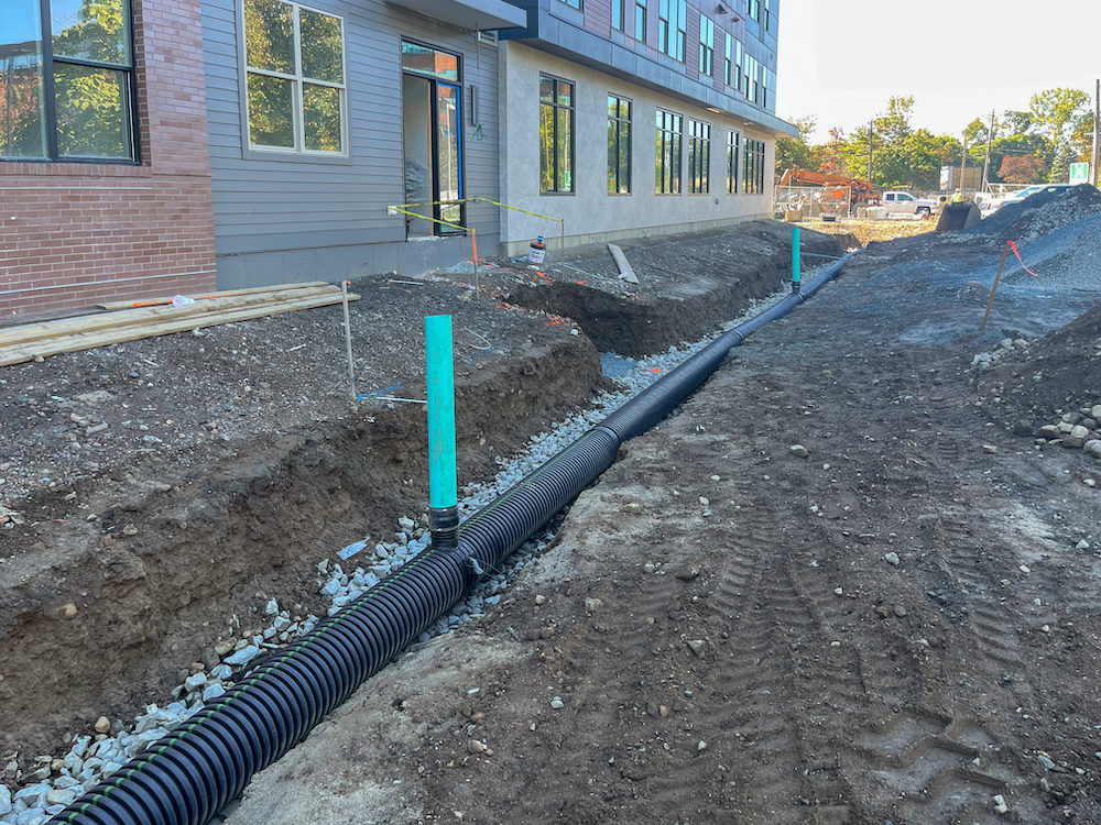 Installation of underground drainage system and stormwater piping at multifamily construction site in Stoneham, MA