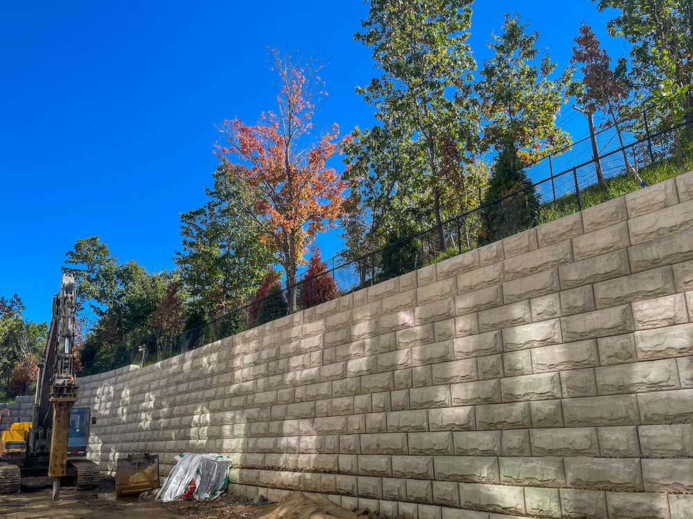 Segmental retaining wall construction supporting elevated grade at Stoneham multifamily development