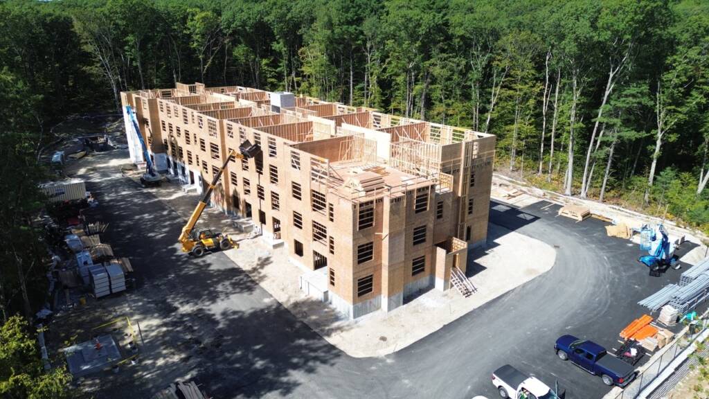 Aerial view of residential building framing and construction activity at Franklin Grove Apartments in Franklin, Massachusetts.
