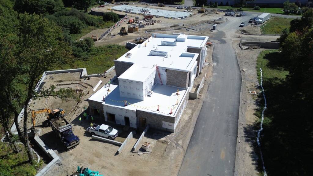 Aerial view of clubhouse building and sitework progress at Franklin Grove Apartments, a residential development in Franklin, MA.